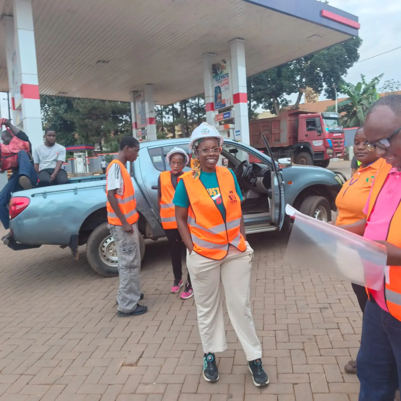 The IGES team in orange vests and hard hats gathered beside an IGES pickup